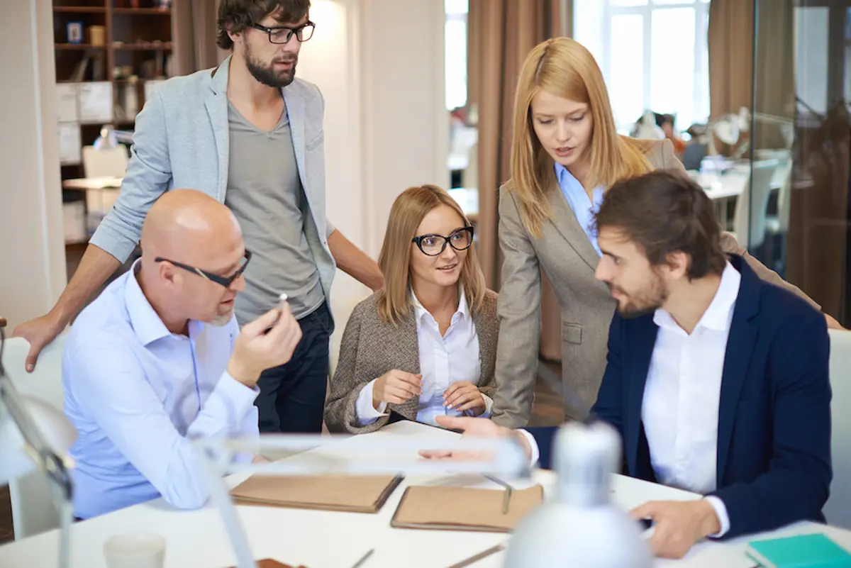 team-management-profil-auswertung-im-team Team bespricht eine Auswertung am Tisch: Arbeit mit dem Team Management Profil